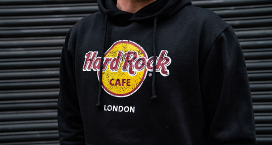 A close up shot of a person wearing a Hard Rock Classic Logo hoodie in black