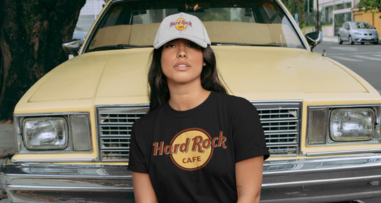 A person wearing a Hard Rock Classic Logo t-shirt in black with a gray Hard Rock Cafe hat