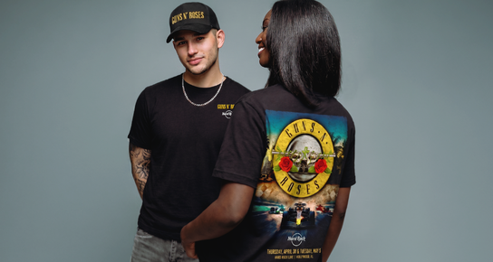Male and female models in black Guns N&rsquo; Roses tees, back graphic featuring Hard Rock racing design..