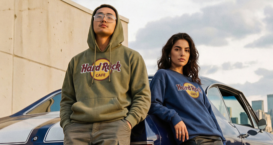 New Classic Logo Hoodies; A person wearing a Olive Green Hard Rock Classic Logo Hoodie looking left with a train moving behind him.