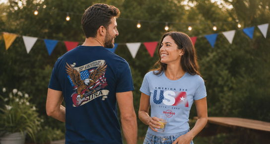Man and woman wearing America 250 graphic tees at a backyard celebration with patriotic banners and string lights.
